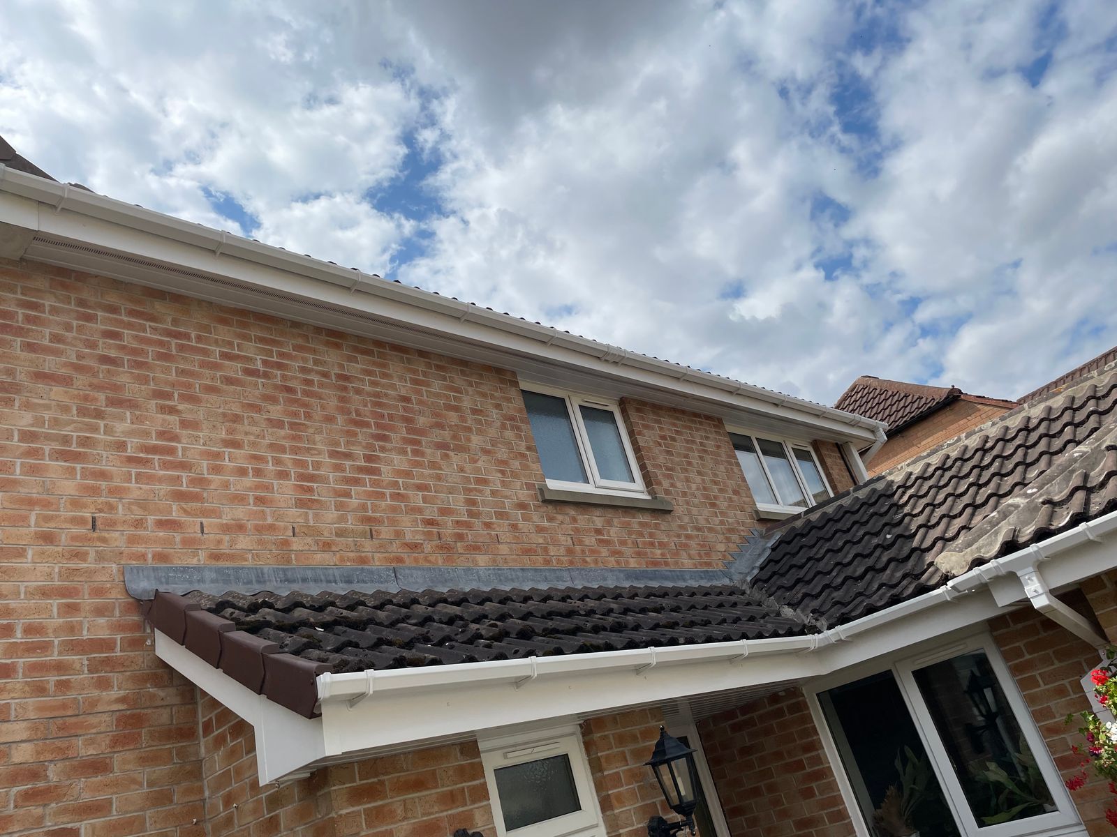 Clean white fascia and soffit against a brick house